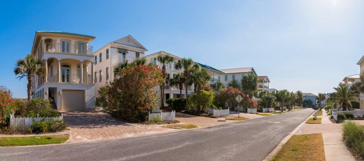 Miramar Beach house rentals along a palm-lined coastal street with luxury homes