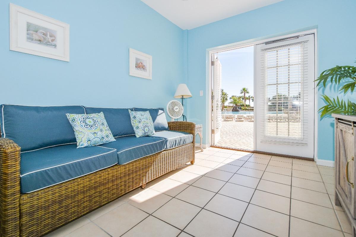 Interior view of a beachfront cabana room with light tile flooring and a sky blue wall.
