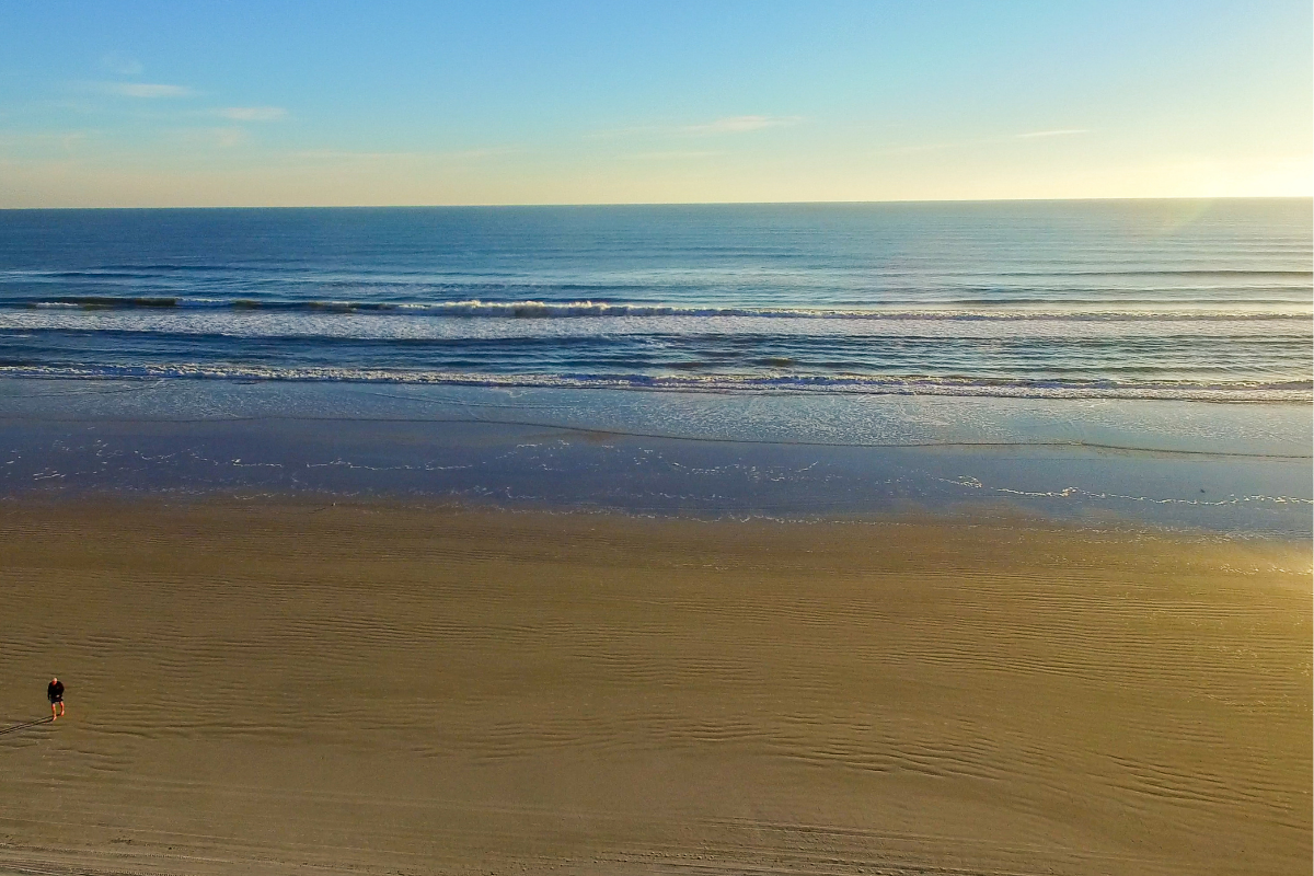 peaceful shoreline at sunrise near South Walton rentals, featuring wide sandy beaches and gentle waves along Florida’s Emerald Coast.